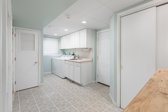 laundry room with washing machine and clothes dryer, baseboards, recessed lighting, cabinet space, and a sink