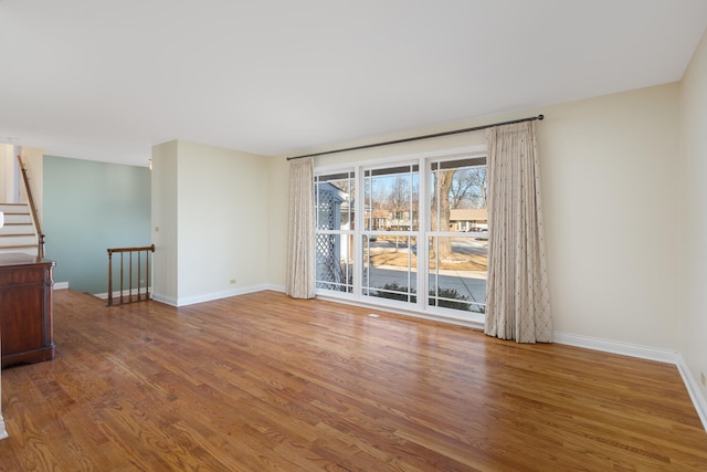 spare room featuring baseboards and wood finished floors