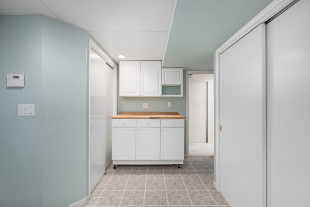 kitchen featuring open shelves, white cabinets, and butcher block counters