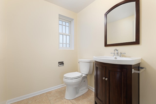 bathroom with tile patterned flooring, toilet, vanity, and baseboards