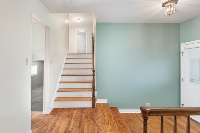 staircase with wood finished floors and baseboards