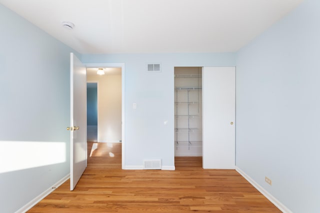 unfurnished bedroom featuring a closet, visible vents, baseboards, and light wood-style floors