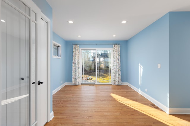 empty room featuring recessed lighting, baseboards, and light wood-style flooring