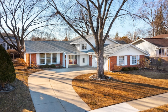 view of front facade featuring concrete driveway, a garage, brick siding, and roof with shingles