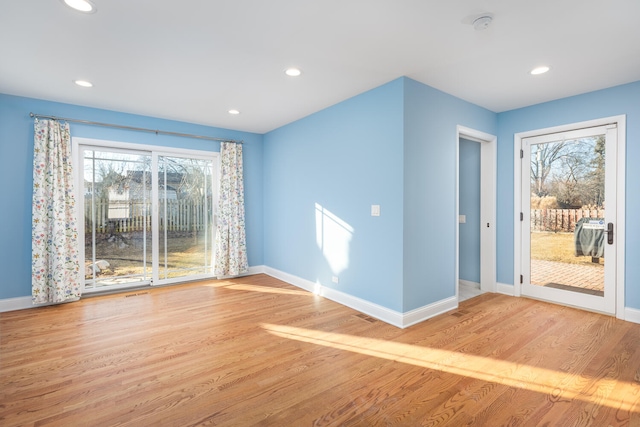 empty room featuring plenty of natural light, baseboards, and wood finished floors