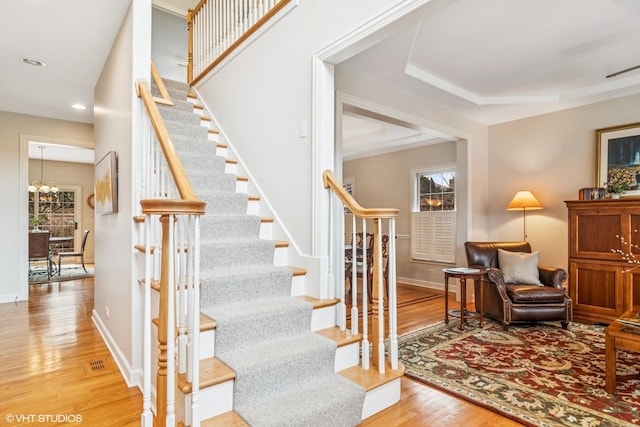 stairway with visible vents, baseboards, wood finished floors, a chandelier, and recessed lighting