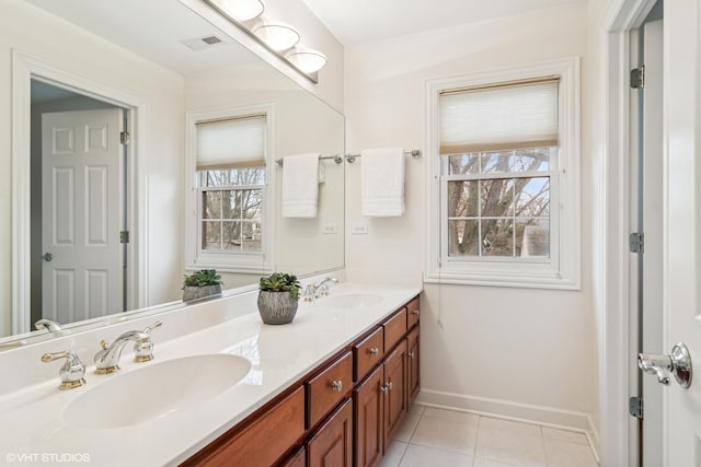 bathroom with tile patterned flooring, a sink, visible vents, and baseboards