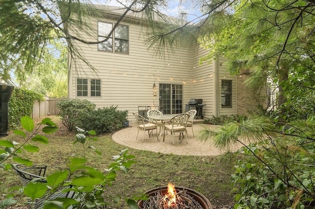 back of house with an outdoor fire pit, fence, and a patio