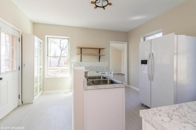 1803 Guion St, Ottawa, IL 61350 - kitchen with open shelves, a sink, white refrigerator with ice dispenser, light countertops, and baseboards