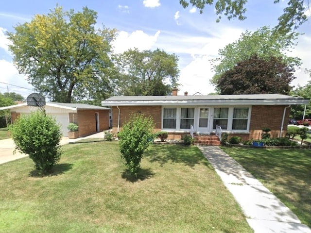 ranch-style home with a garage, a chimney, a front lawn, and brick siding