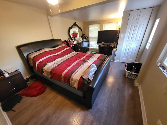 bedroom with baseboards and dark wood-type flooring