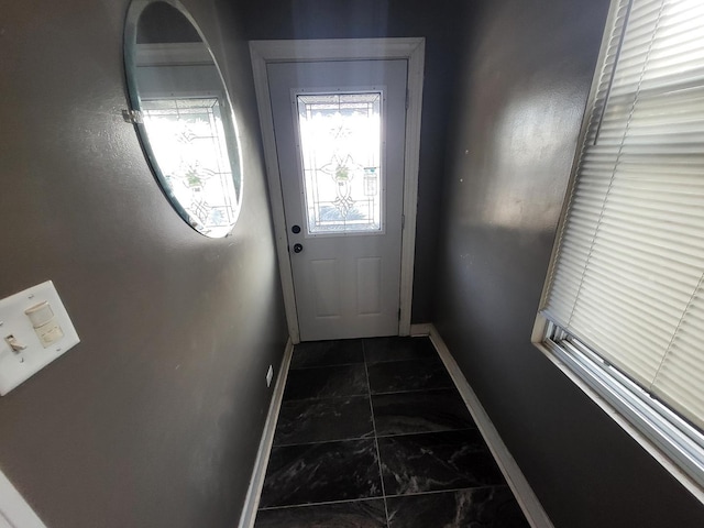 doorway to outside featuring baseboards