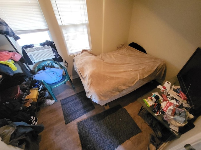 bedroom with cooling unit and wood finished floors