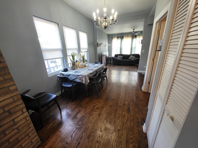 dining space with baseboards, dark wood-style flooring, and an inviting chandelier