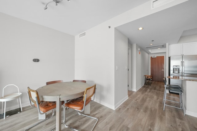 dining room featuring light wood-style flooring, visible vents, baseboards, and recessed lighting