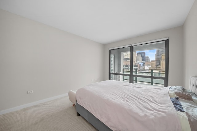 bedroom with carpet flooring, a city view, and baseboards