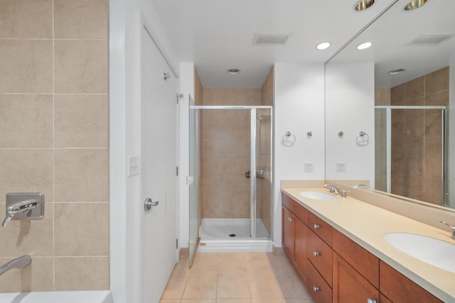 bathroom featuring tile patterned flooring, a sink, and a shower stall