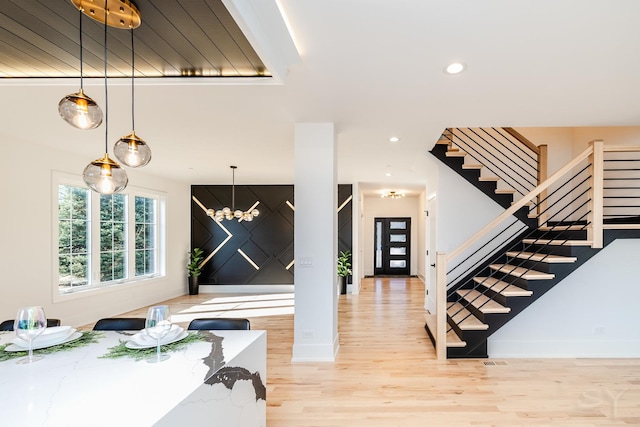 entrance foyer with a chandelier, recessed lighting, baseboards, stairway, and light wood finished floors