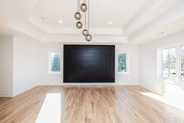 entryway with light wood-type flooring, a raised ceiling, and baseboards