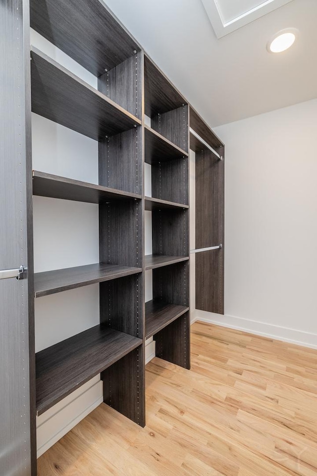 walk in closet with wood finished floors