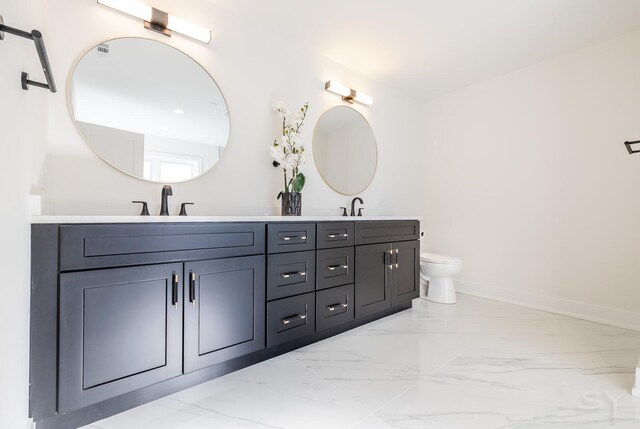 full bathroom with double vanity, baseboards, toilet, marble finish floor, and a sink