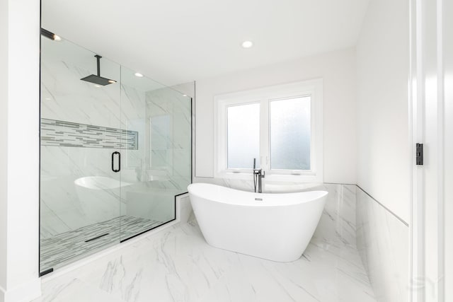 full bathroom featuring a marble finish shower, marble finish floor, a freestanding tub, tile walls, and recessed lighting