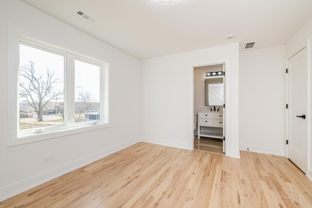 unfurnished bedroom with light wood-type flooring, visible vents, and baseboards