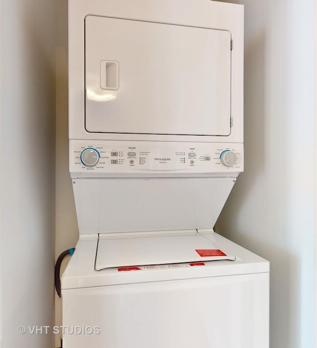 washroom featuring stacked washer / drying machine and laundry area