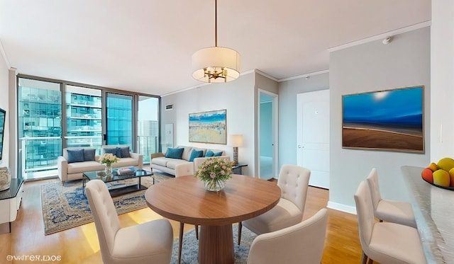 dining room featuring crown molding, baseboards, wood finished floors, and floor to ceiling windows