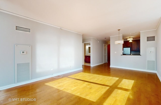 unfurnished living room with visible vents and wood finished floors