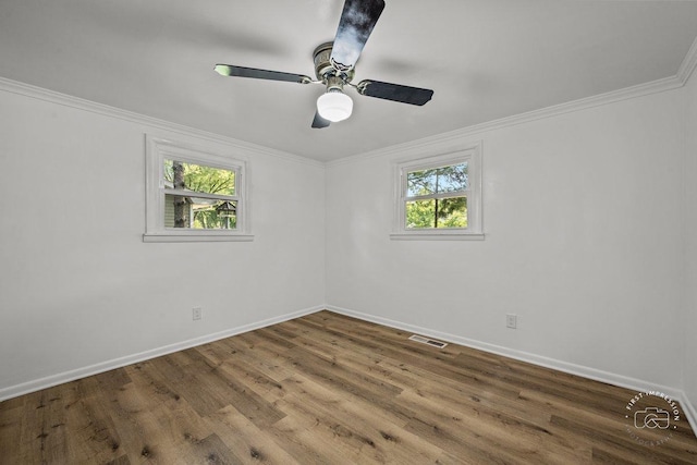 spare room featuring ceiling fan, wood finished floors, visible vents, baseboards, and ornamental molding