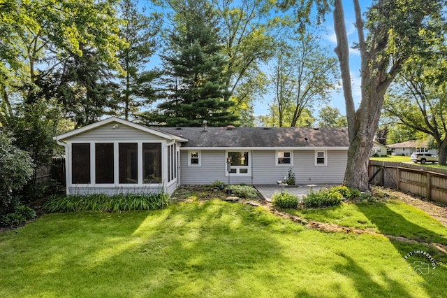 rear view of house with a yard, a patio area, a fenced backyard, and a sunroom