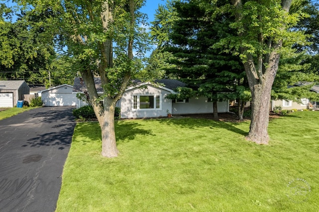 ranch-style home with an outbuilding, a detached garage, and a front lawn