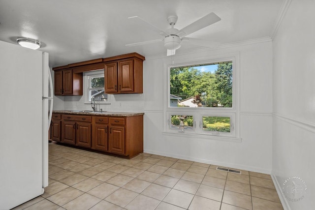 kitchen with tasteful backsplash, visible vents, a ceiling fan, freestanding refrigerator, and a sink