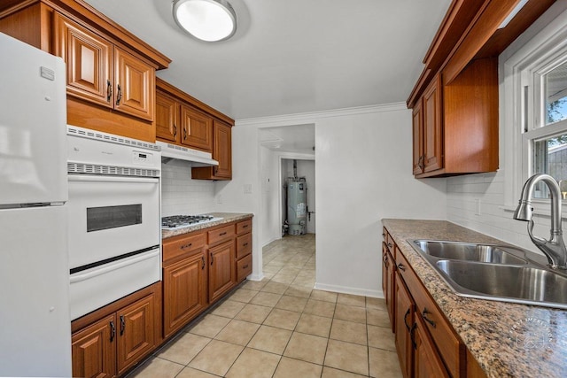 kitchen featuring white appliances, under cabinet range hood, water heater, a sink, and a warming drawer