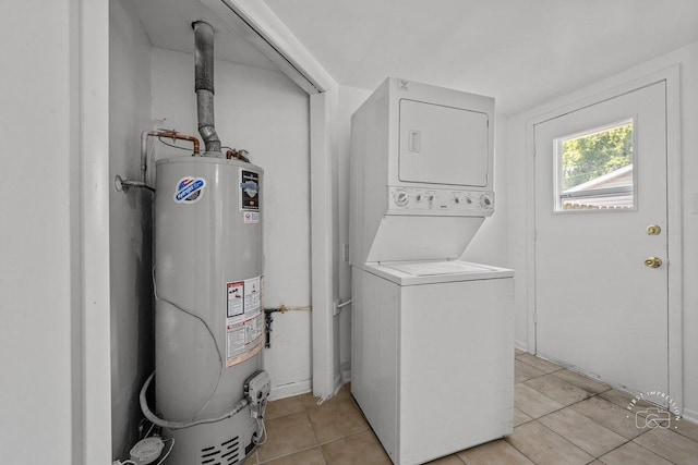 laundry room featuring light tile patterned floors, laundry area, gas water heater, and stacked washing maching and dryer