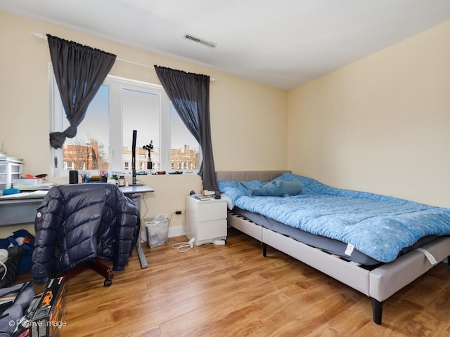 bedroom featuring visible vents and wood finished floors