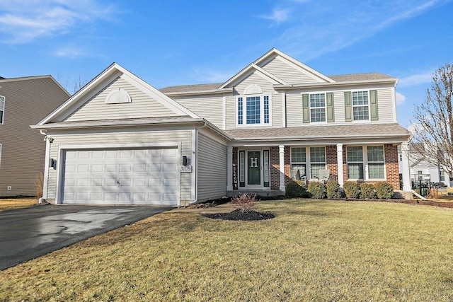 traditional home with aphalt driveway, a front yard, brick siding, and an attached garage