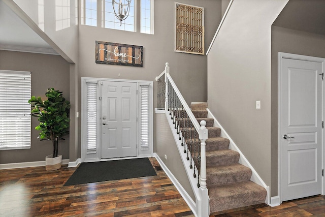 foyer featuring stairs, baseboards, and wood finished floors