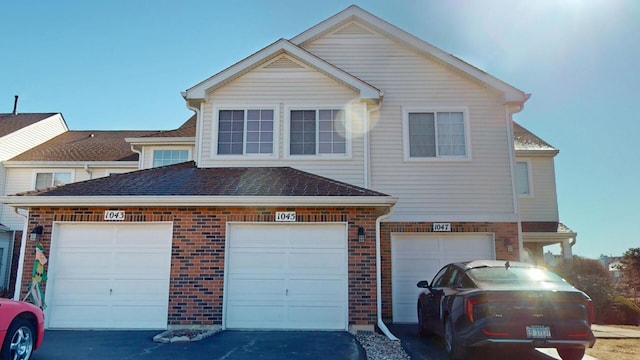 view of front facade featuring aphalt driveway and brick siding