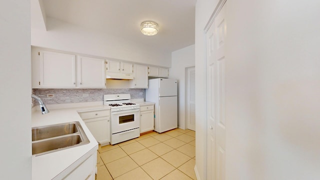 kitchen featuring a sink, under cabinet range hood, backsplash, white appliances, and light tile patterned flooring