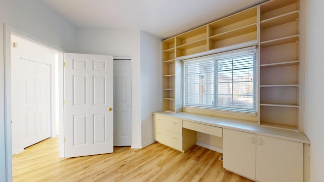 unfurnished office featuring light wood-style flooring and built in study area