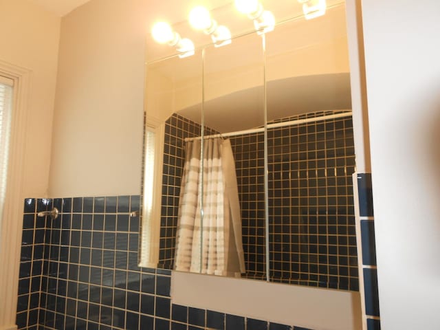 full bathroom featuring tile walls and tiled shower