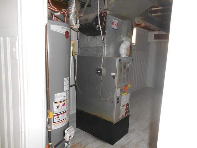 utility room with heating unit and water heater