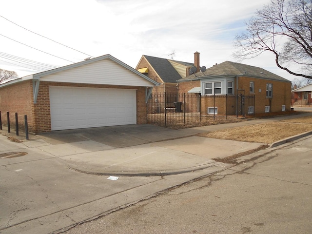 view of front of property with a garage, a fenced front yard, and brick siding