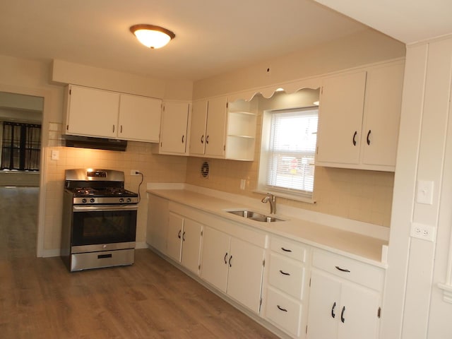 kitchen with tasteful backsplash, a sink, stainless steel gas range oven, and open shelves