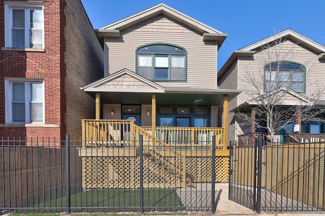 view of front of home with covered porch, stairway, and fence