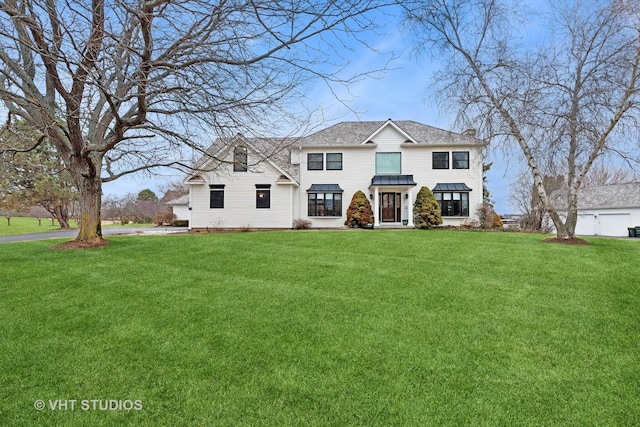 view of front of home featuring metal roof, a chimney, a front lawn, and a standing seam roof