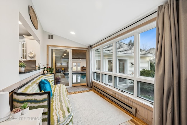 sunroom / solarium featuring a baseboard heating unit, visible vents, and vaulted ceiling