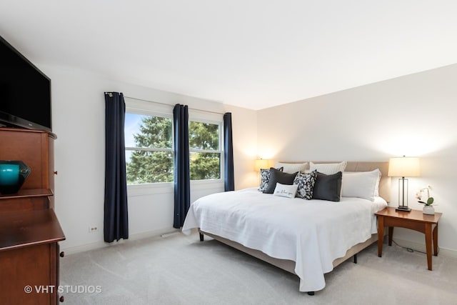 bedroom with baseboards and light colored carpet